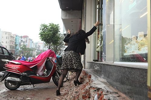 People in Hanoi swing doors and put ladders into their houses after the 'tornado' cleared the sidewalks 3